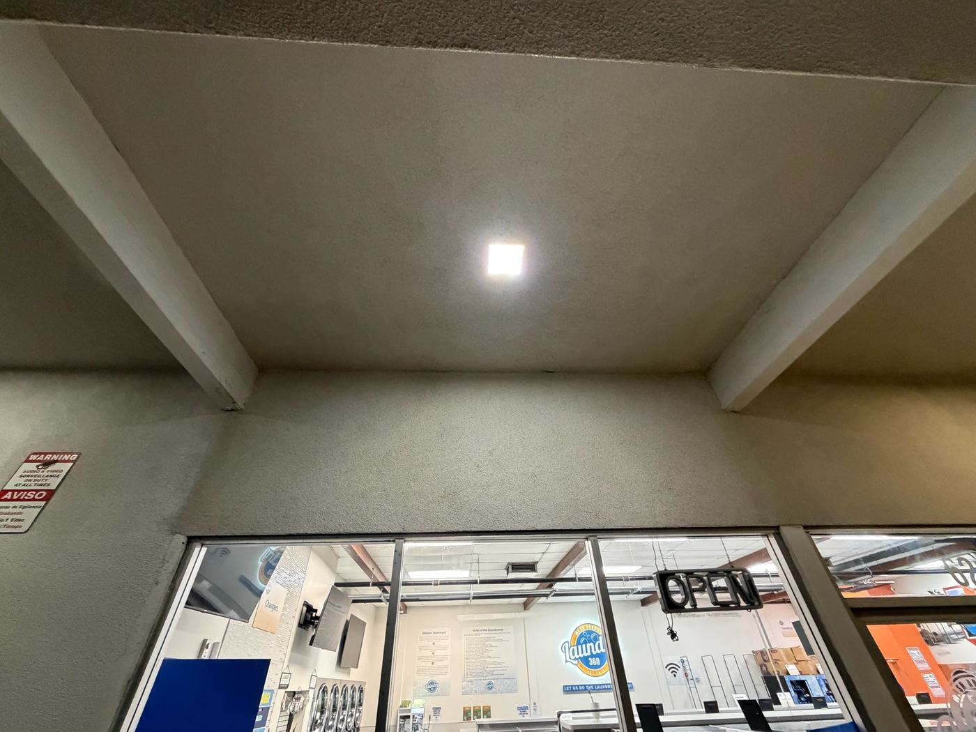 After: clean laundromat entrance overhang, dust and cobwebs fully removed