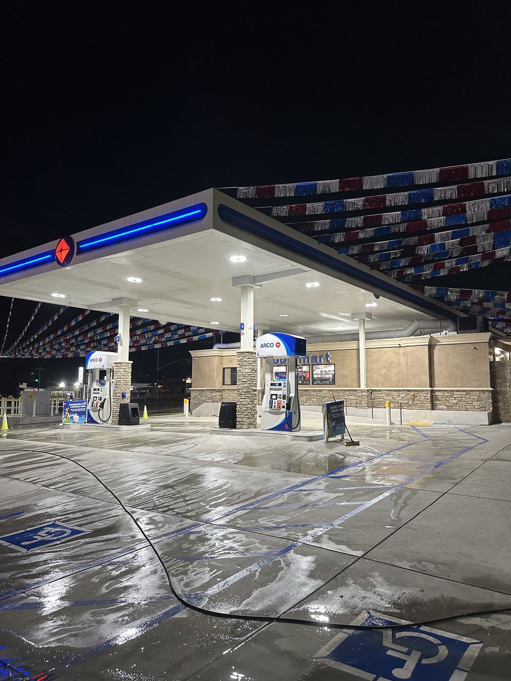 Freshly cleaned ARCO gas station canopy and fuel island lot at night