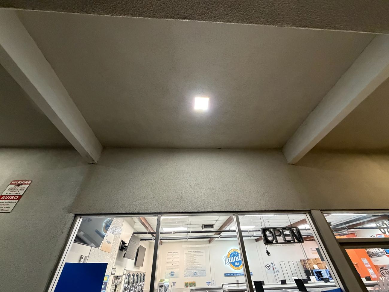 After: clean laundromat entrance overhang, dust and cobwebs fully removed