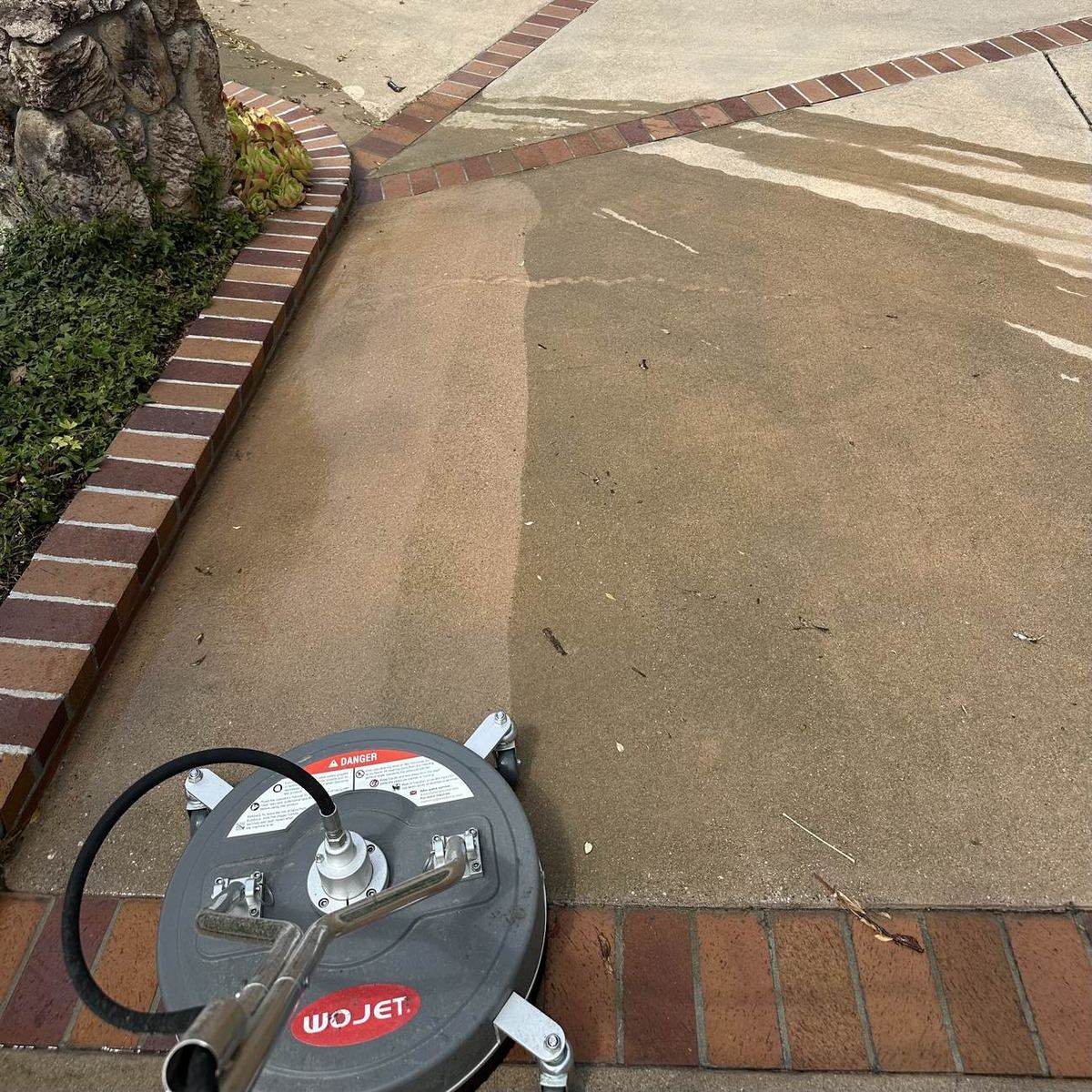 Elite Home Exterior Maintenance surface cleaner pressure washing a concrete driveway